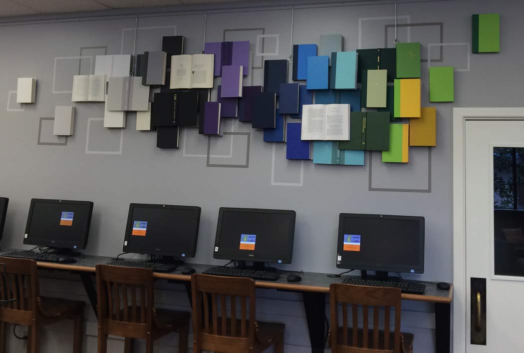 library computer terminals along wall with colorful book artwork.