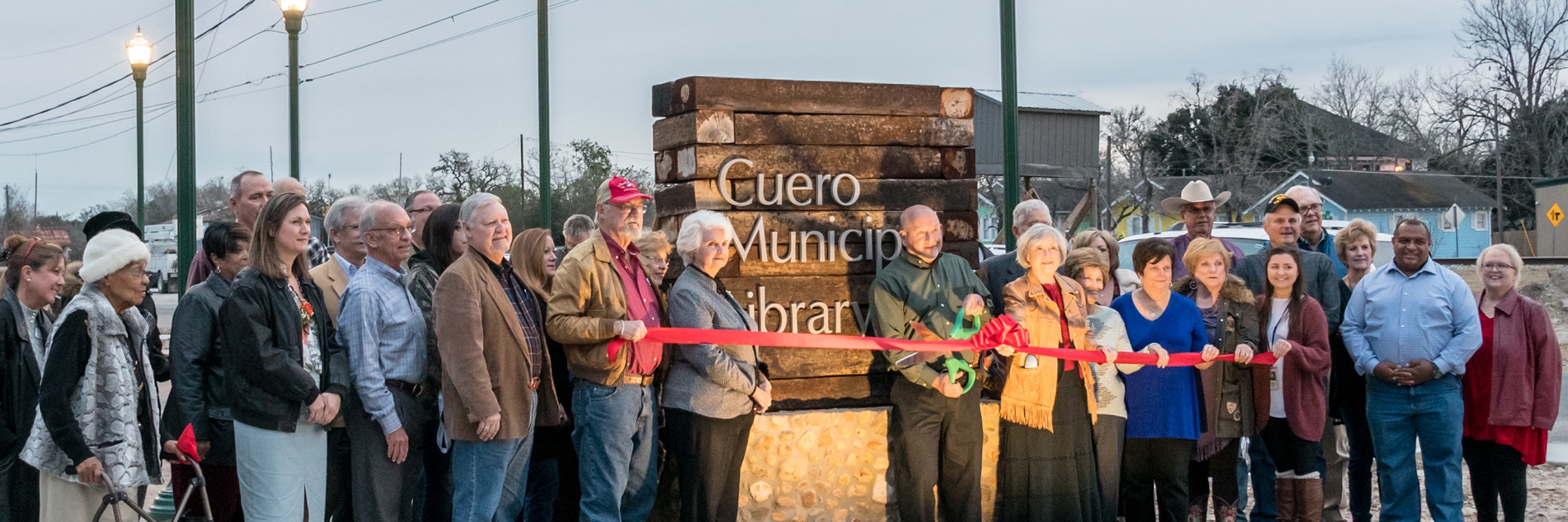 cuero library ribbon cutting in front of signage